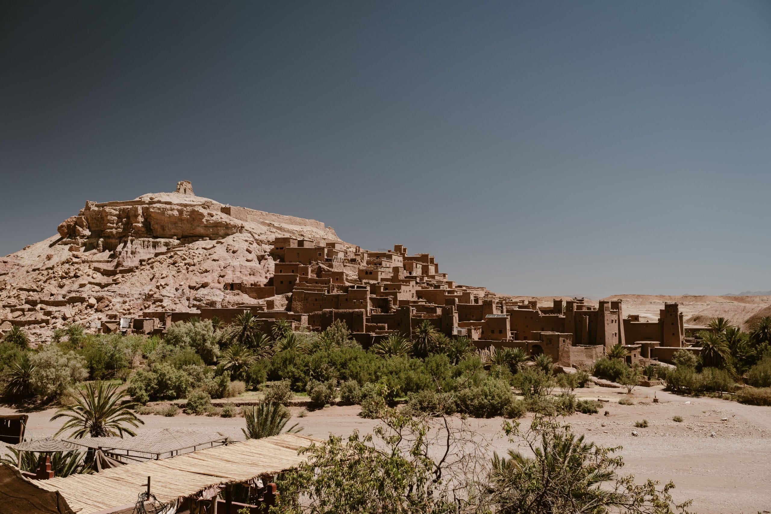 The historic Ksar of Ait Ben Haddou under a clear blue sky in Morocco.