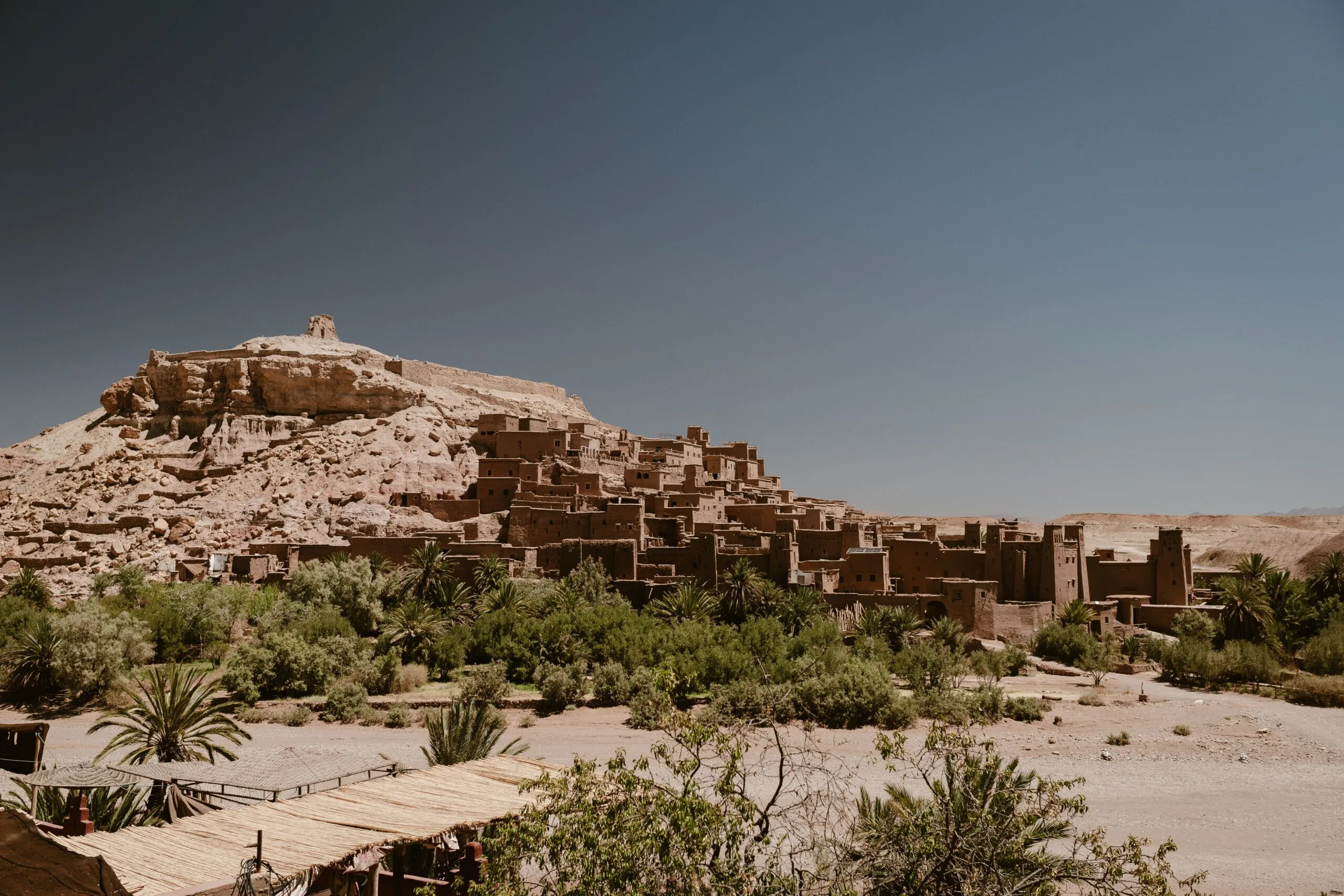 The historic Ksar of Ait Ben Haddou under a clear blue sky in Morocco.